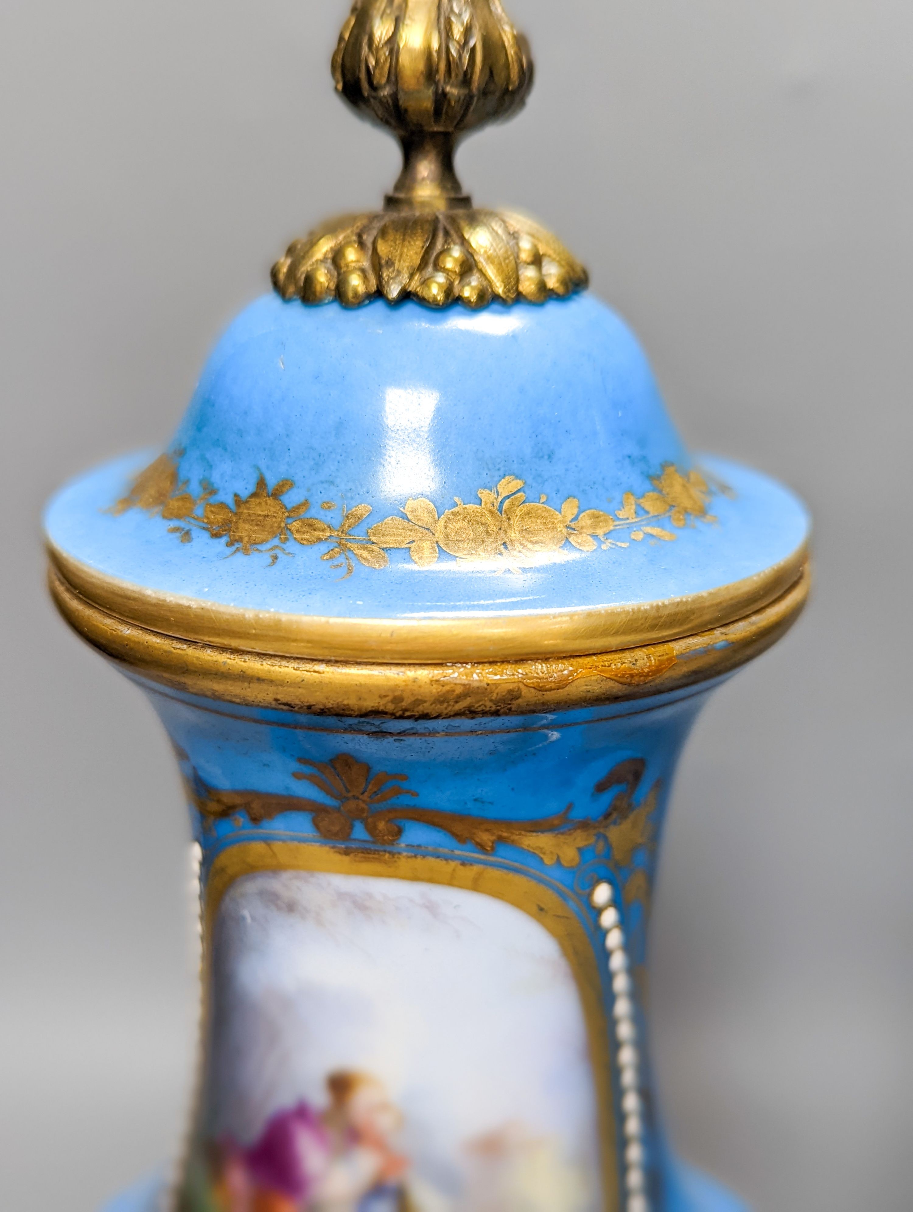 A pair of Sevres style porcelain bleu celeste ground vases and covers, 34cm